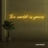 The World Is Yours neon sign in golden yellow for visionary decor, inspiring spaces, and modern walls.