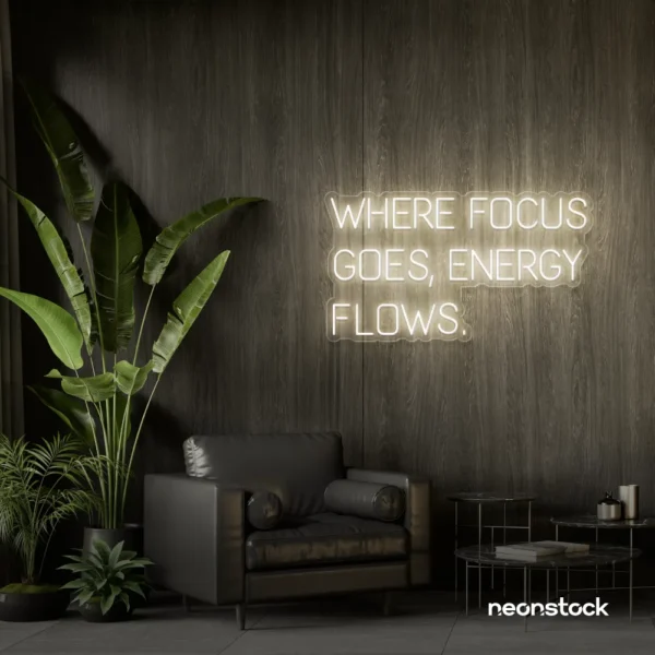 Where Focus Goes Energy Flows neon sign in neutral white for productivity decor and creative inspiration.