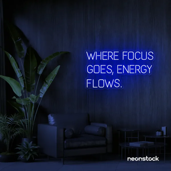 Where Focus Goes Energy Flows neon sign in dark blue for productivity decor and creative inspiration.