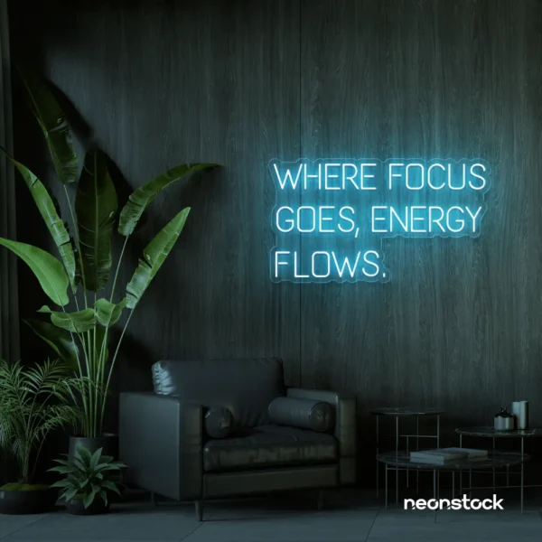 Where Focus Goes Energy Flows neon sign in ice blue for productivity decor and creative inspiration.