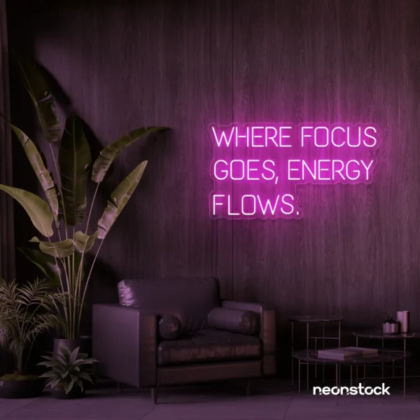Where Focus Goes Energy Flows neon sign in pink for productivity decor and creative inspiration.