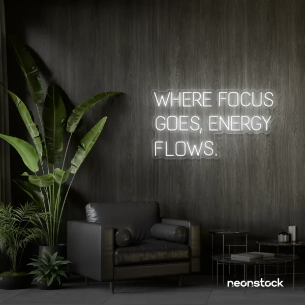 Where Focus Goes Energy Flows neon sign in white for productivity decor and creative inspiration.