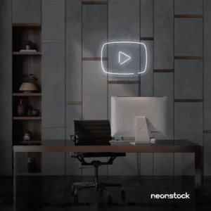 White play button neon sign on gray office wall above a modern desk