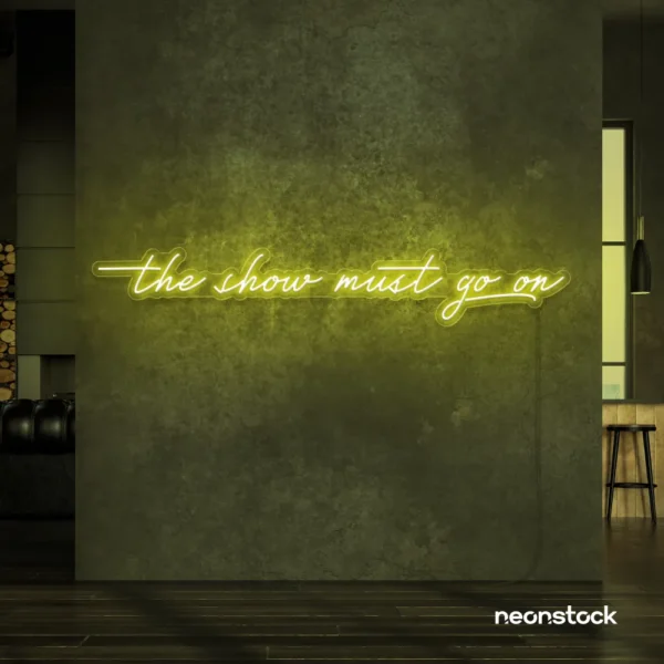 The Show Must Go On neon sign in lemon yellow for stage decor, creative rooms, and dramatic interiors.